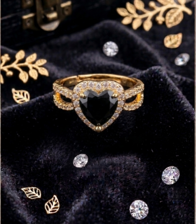 Black heart-shaped gold-tone ring with sparkling halo and pavé-style band on black velvet by https://vastorastore.com/