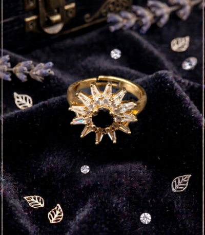 Golden sunburst statement ring with black center stone and sparkling decorative accents by https://vastorastore.com/