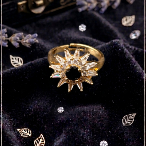 Golden sunburst statement ring with black center stone and sparkling decorative accents by https://vastorastore.com/