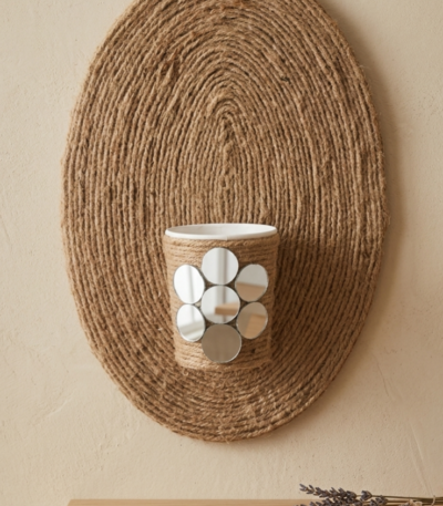 Rustic oval jute rope wall hanging with central decorative holder and mirror accents by https://vastorastore.com/