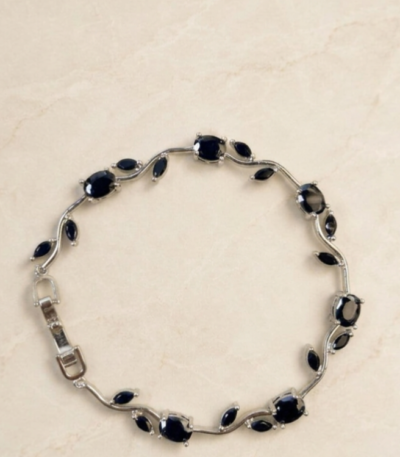 Black Tulip Bracelet with glossy black oval stones, marquise-shaped accents, and silver-tone detailing on a cream background.