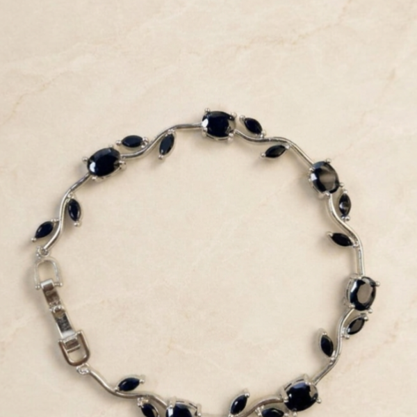 Black Tulip Bracelet with glossy black oval stones, marquise-shaped accents, and silver-tone detailing on a cream background.