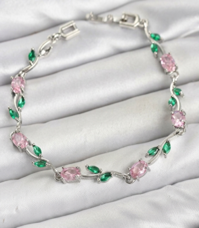 Tulip Bracelet with pink oval stones, green leaf-shaped accents, and a silver-tone floral design on white satin.