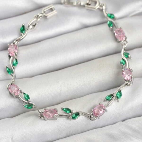 Tulip Bracelet with pink oval stones, green leaf-shaped accents, and a silver-tone floral design on white satin.