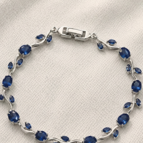 Tulip Bracelet with deep blue oval stones, leaf-shaped accents, and silver-tone detailing on cream fabric.
